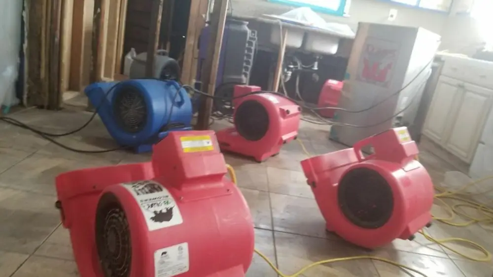 Red air movers drying a room
