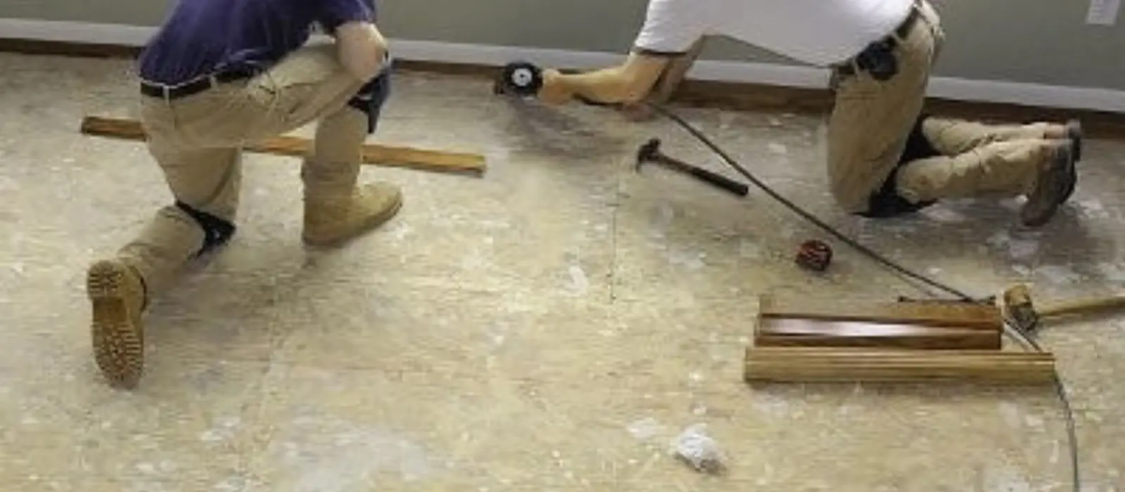 Two workers installing new flooring after water damage